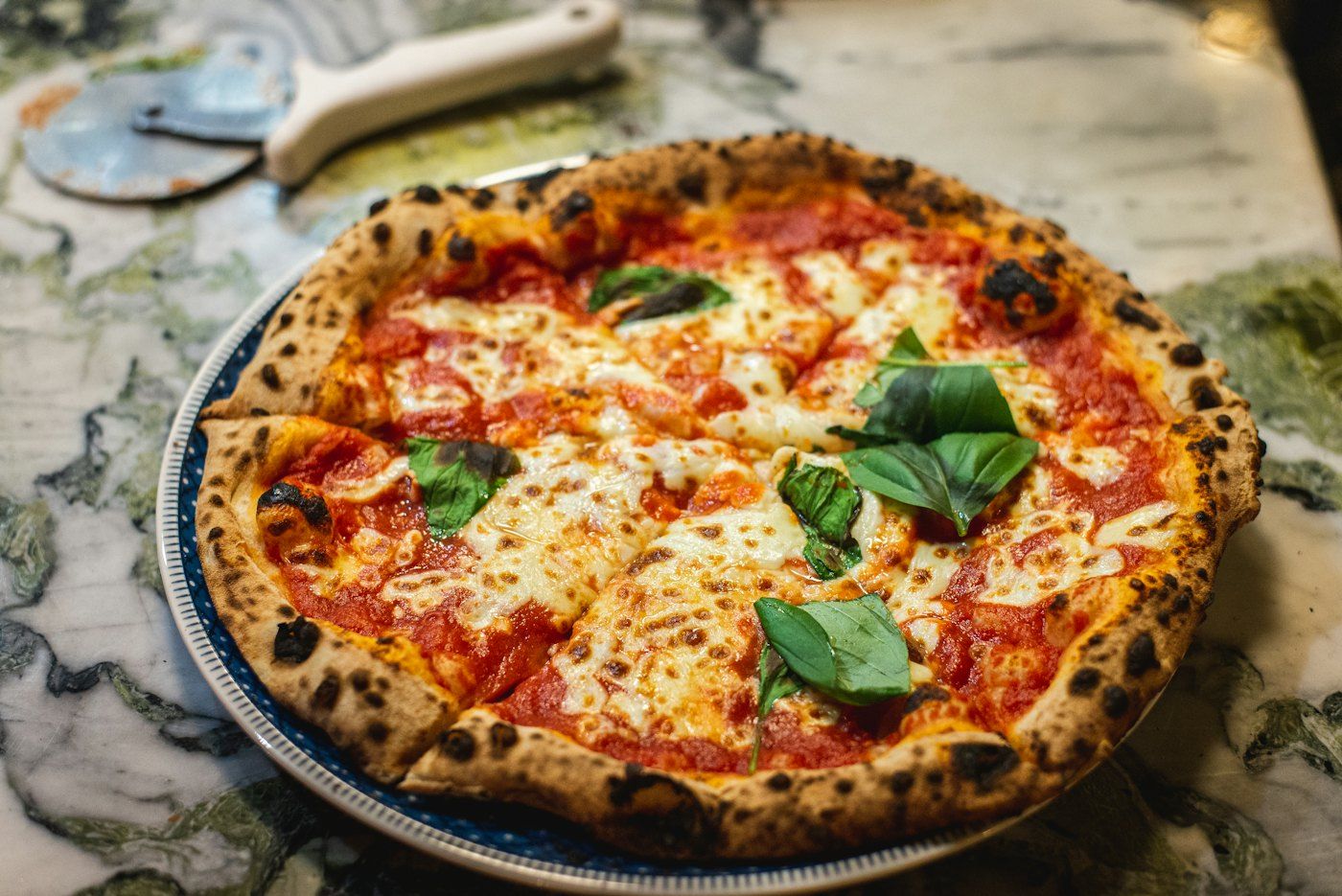 Pizza margherita con basilico appena sfornata